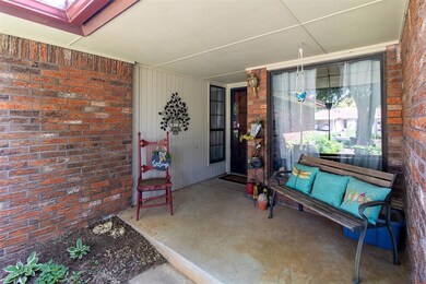 View of exterior entry featuring brick siding and a porch