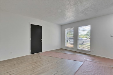 Empty room featuring a textured ceiling, wood fin