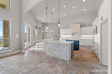 Kitchen with a towering ceiling, a spacious islan