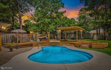 Pool at dusk with a pergola, a fenced backyard, a 