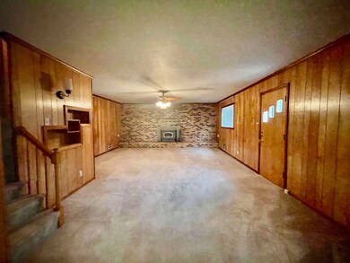 Unfurnished living room with ceiling fan, a wood s