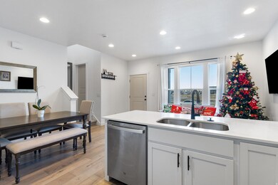 Kitchen featuring stainless steel dishwasher, light wood-style floors, recessed lighting, white cabinets, and light stone counters
