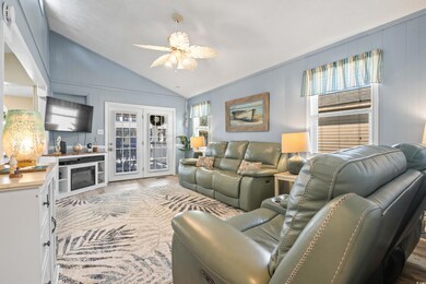 Living room with lofted ceiling, ceiling fan, and 