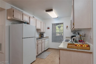 Kitchen featuring white appliances, light countert