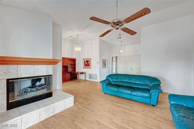 Living room featuring vaulted ceiling, a ceiling f