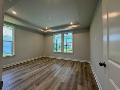 Unfurnished room with a raised ceiling, wood finished floors, baseboards, and recessed lighting