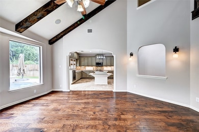  It opens into a modern kitchen with an island and