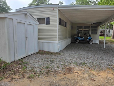 View of side of property with a carport and driveway