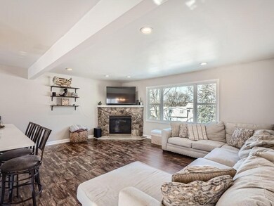 Living Room with a corner brick fireplace with stone surround.   Open flow to the Kitchen.  Big picture window has views of the neighborhood park.