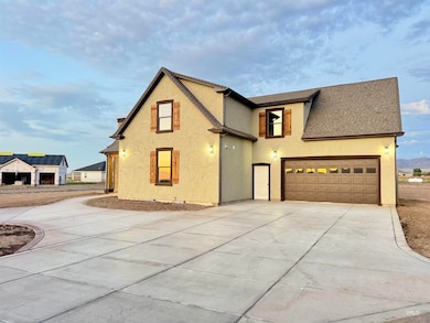 View of front of home with stucco siding, driveway, a garage, and a shingled roof