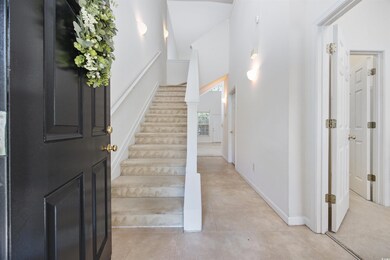Foyer entrance with stairs and light tile patterned floors