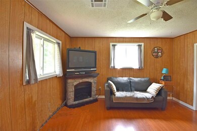 Living room featuring a fireplace, wooden walls, c