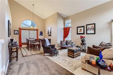 Carpeted living room with a chandelier, baseboards