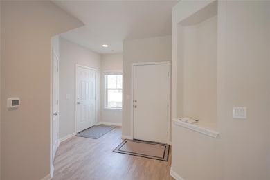 Foyer entrance featuring wood finished floors, ba