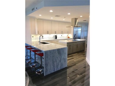 Oversized slabs in exotic blue diamond marble and opal white marble center island finished with waterfall edges.