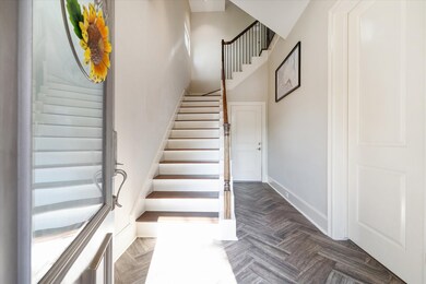 Foyer with wood-like tile set in a herringbone pat