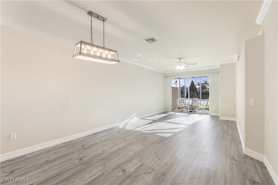 Open living room featuring crown molding, wood finished floors, and ceiling fan