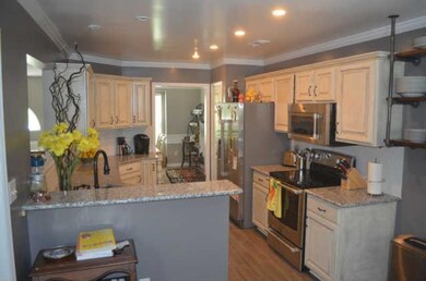 Kitchen area features new lighting, new stainless appliances and tile flooring.  Custom shelving stays with the house.