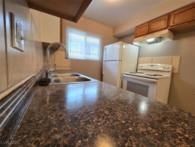 Kitchen featuring white appliances, a sink, under