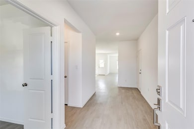 Corridor with light wood finished floors and recessed lighting
