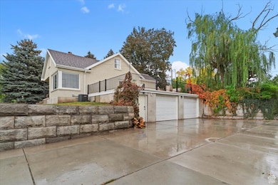 View of property exterior featuring concrete driveway and a balcony