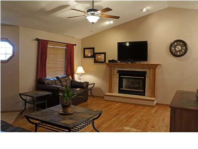 The living room has hardwood flooring, vaulted cei