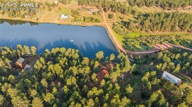 Aerial overview of property's location featuring a large body of water and a heavily wooded area