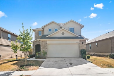 Traditional-style house featuring brick siding, concrete driveway, a garage, and roof with shingles