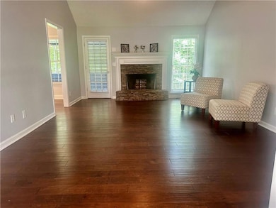 Living area with vaulted ceiling, dark wood-style 