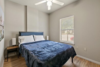 Bedroom with baseboards, a ceiling fan, and wood 