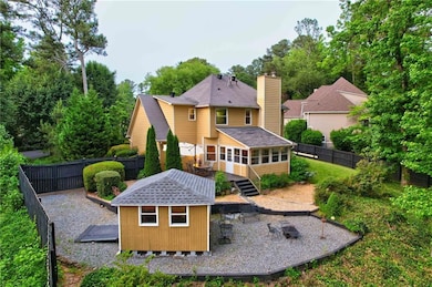 Rear view of house with a fenced backyard, a shingled roof, and a wooden deck
