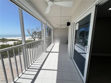Balcony with a ceiling fan, a view of the beach, a