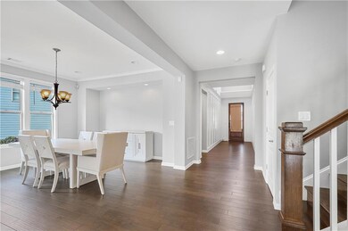 Dining room with a chandelier, dark wood-style floors, stairs, baseboards, and recessed lighting