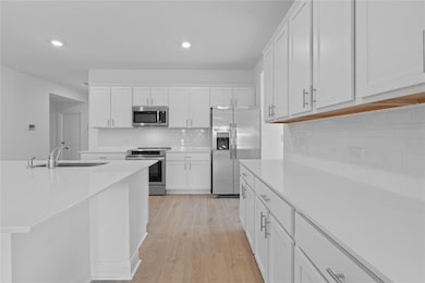 Kitchen featuring stainless steel appliances, lig