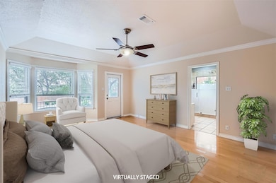Bedroom with light wood-style flooring, a tray ce