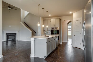 Spacious kitchen - open floorplan - leading into two story family room- not actual home, but same floorplan.  Home for sale has a beautiful two story stone fireplace!