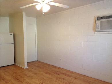 Unfurnished room with a ceiling fan, a wall unit A