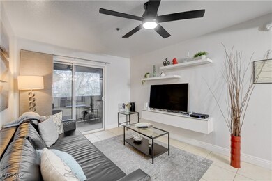 Tiled living room featuring ceiling fan and basebo
