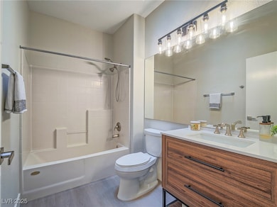 Full bath with toilet, wood finished floors, vanit