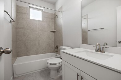 Bathroom featuring vanity, toilet,  shower combin