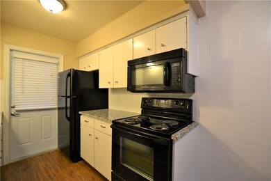 Kitchen featuring dark wood-style floors, white ca