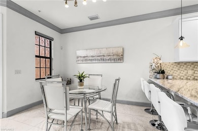 Dining room with ornamental molding and baseboards