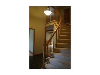 Grand curved staircase in the slate tiled foyer