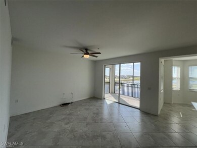 Empty room featuring a water view, ceiling fan, ba