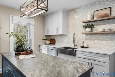 Kitchen with backsplash, open shelves, light stone countertops, dishwasher, and hanging light fixtures