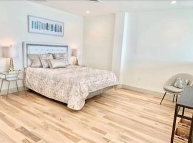 Bedroom with baseboards, wood finished floors, and recessed lighting