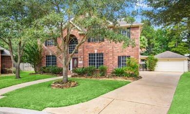 This impressive front elevation is adorned with a lush landscape, 2-story brick entrance and detached garage.