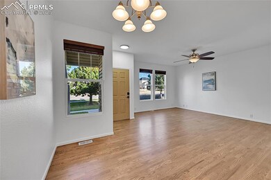 Empty room with light wood-style floors, a chandelier, and ceiling fan