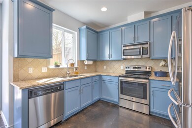 Kitchen with blue cabinets, a sink, finished conc