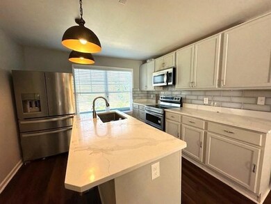 Kitchen with white cabinetry, a kitchen island wit